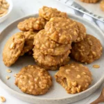 No bake peanut butter oatmeal cookies arranged on a plate, soft and chewy, with oats and chocolate drizzle visible.